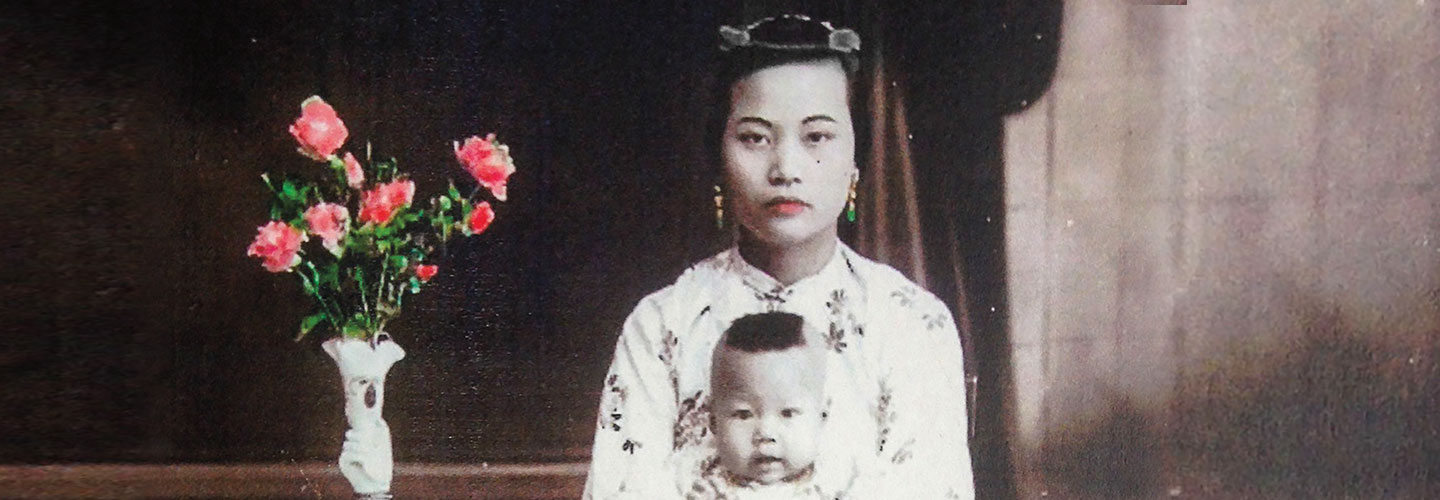 A woman wearing a traditional dress holds her infant son