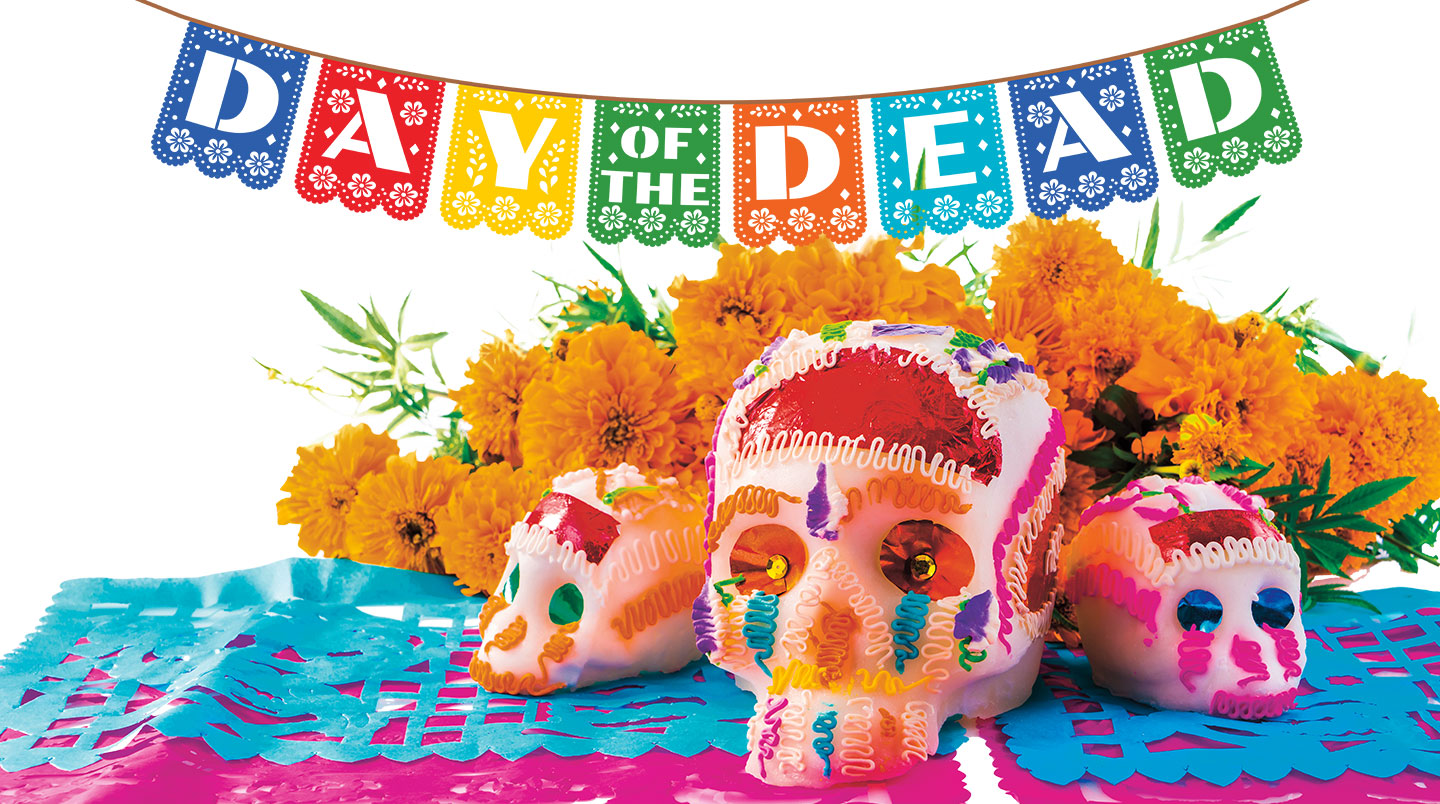 Three stylized and decorated skulls with flowers around them. Text, day of the dead.