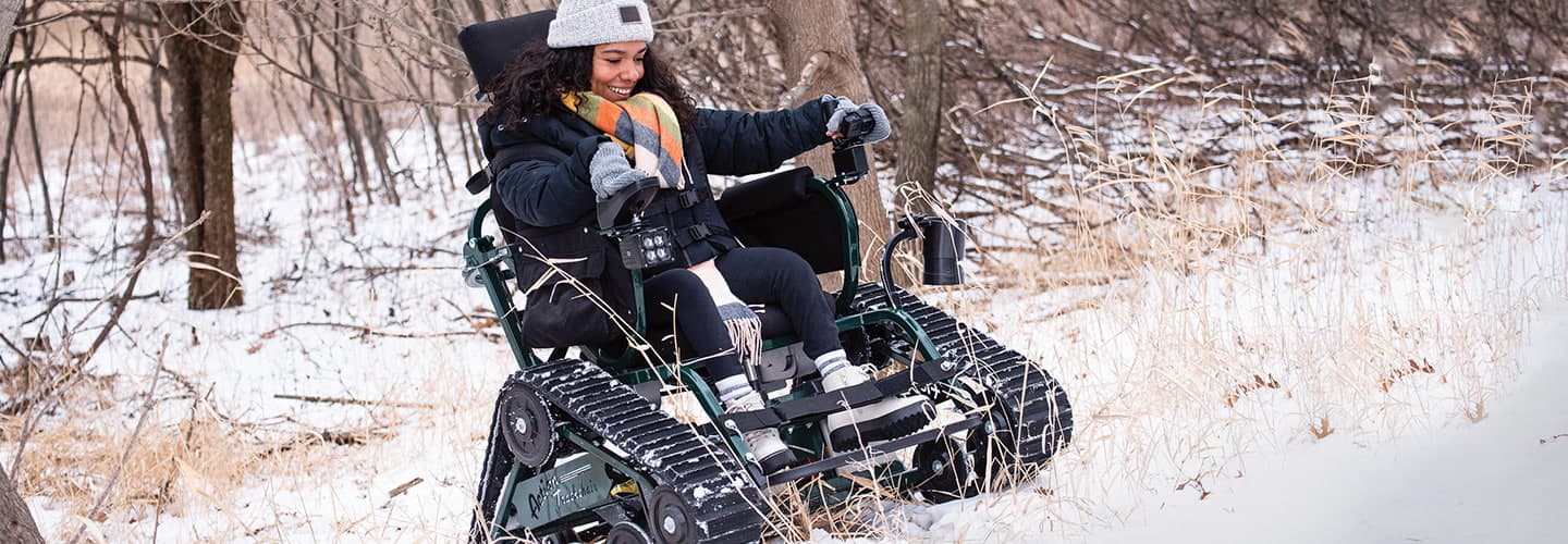 Photo of a person riding a wheelchair that can access different landscapes such as a snow