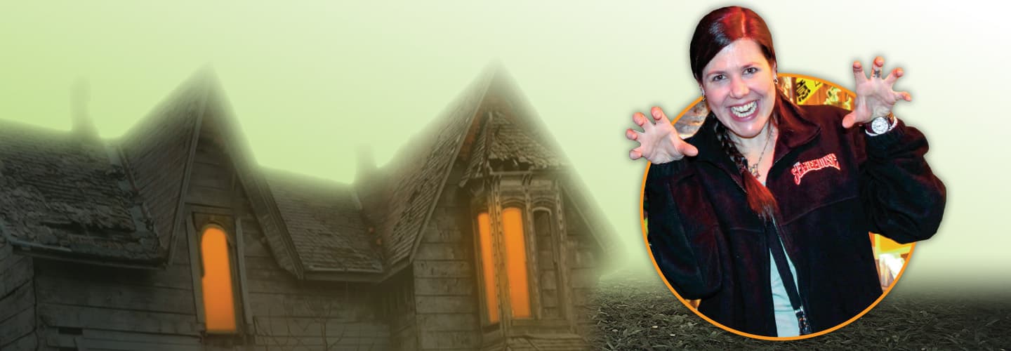 Person making a scary gesture with their face and hands with a haunted house backdrop