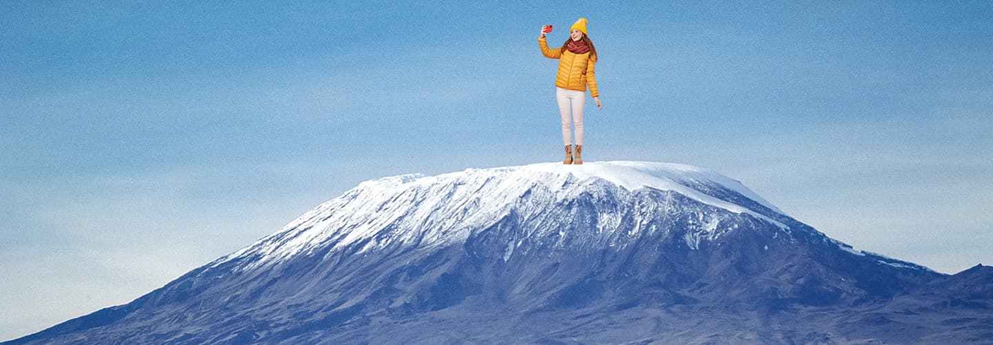 Image of a person photoshopped on a snowy mountaintop