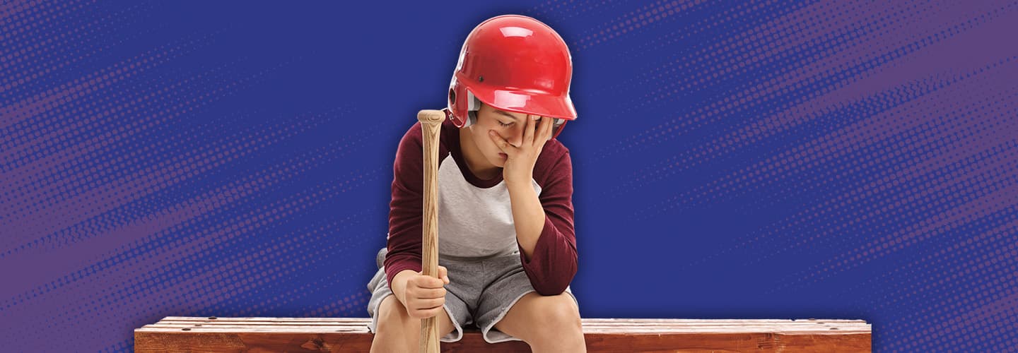 Image of an upset kid baseball player sitting on a bench