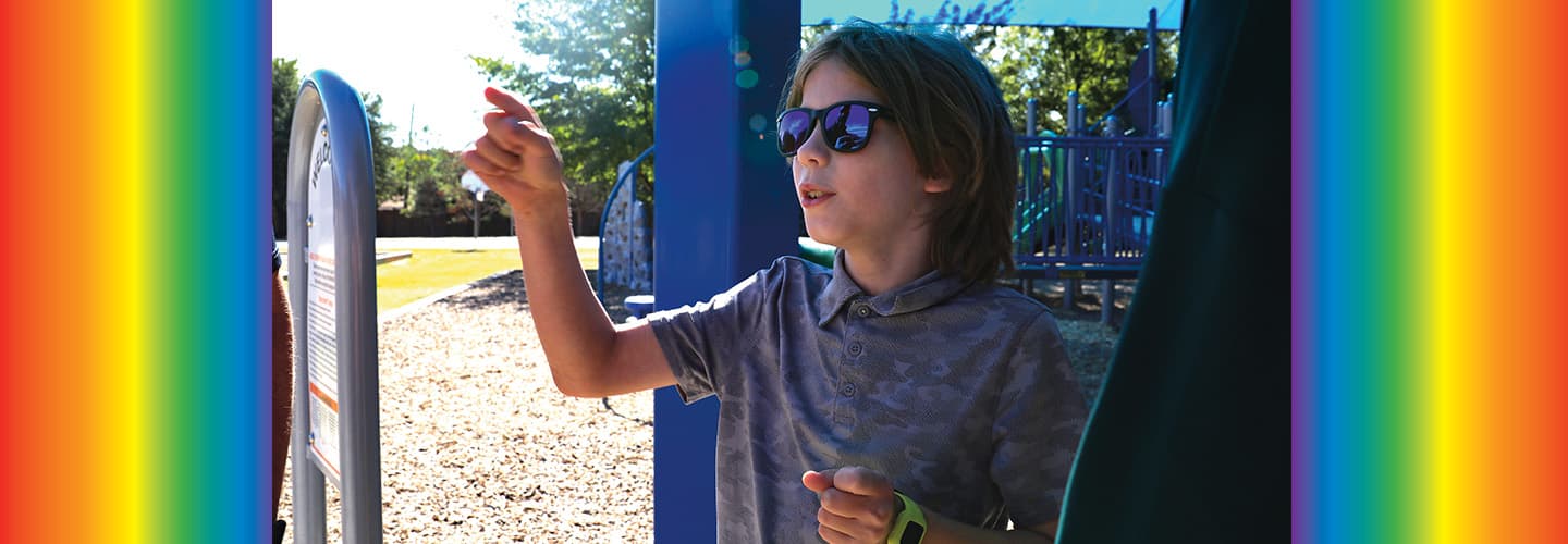 Image of a child at a playground wearing sunglasses