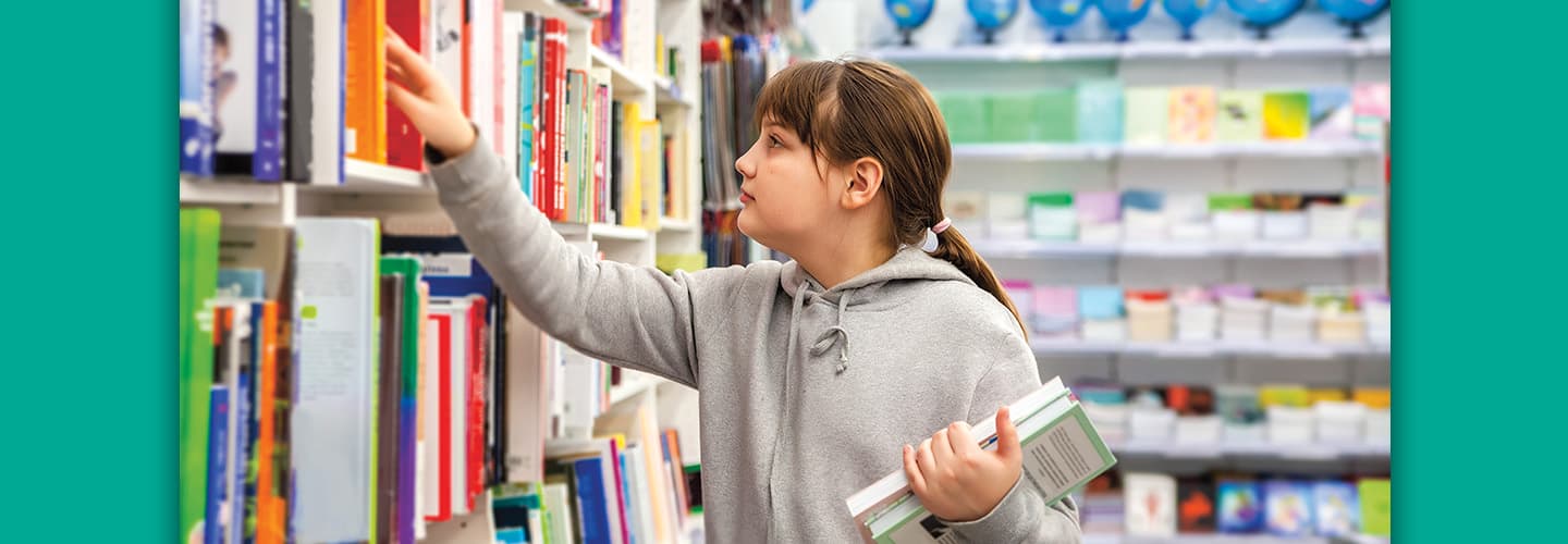 Image of a student perusing books at the library