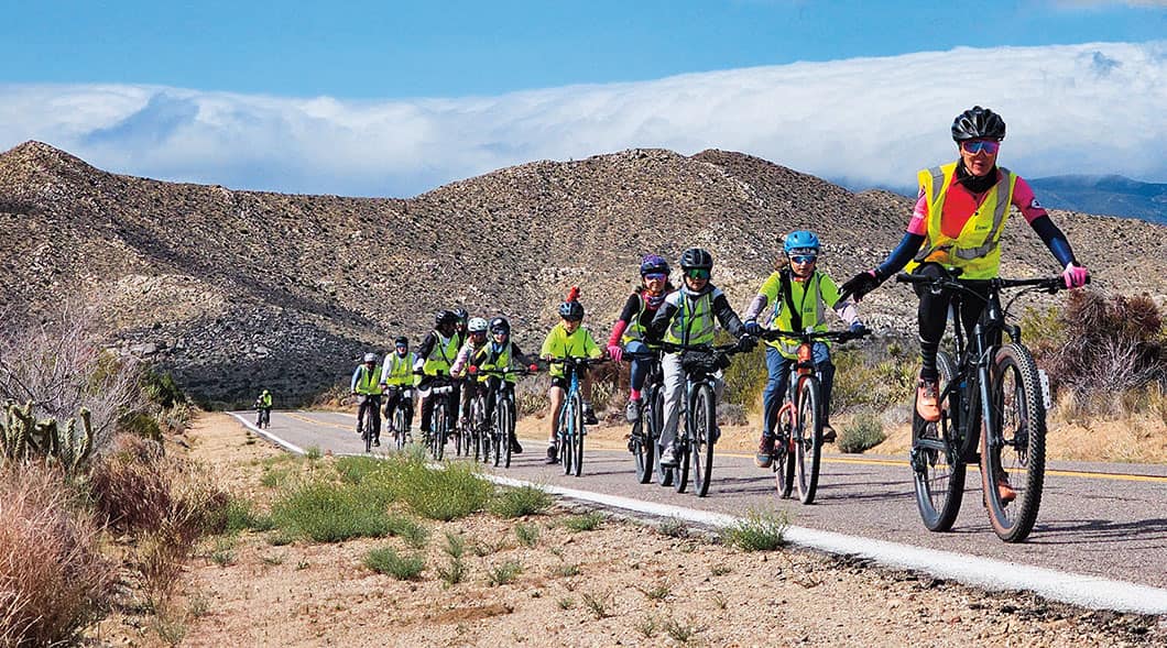 Image of a group of bikers traveling through desert landscape