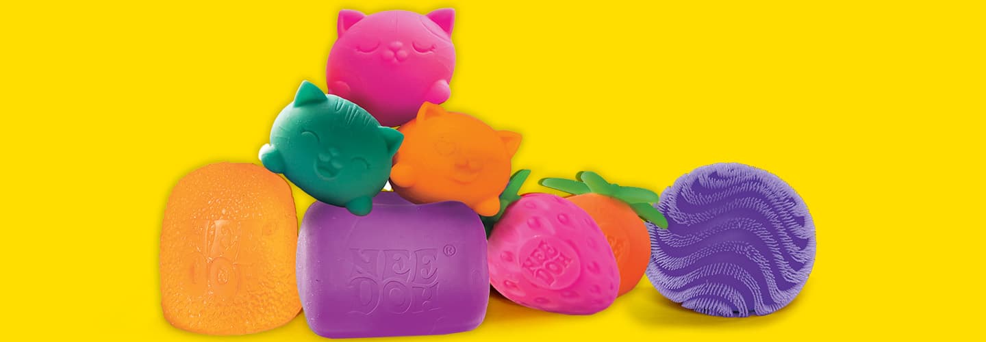 A collection of colorful Nee Doh squishy toys in cat and fruit shapes on a yellow background
