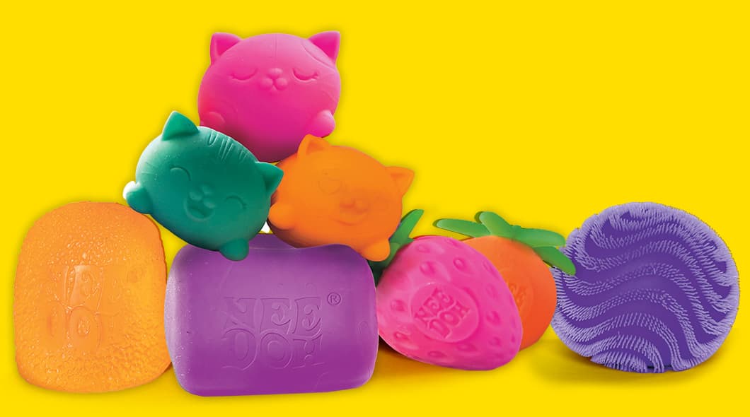 A collection of colorful Nee Doh squishy toys in cat, fruit, and round shapes