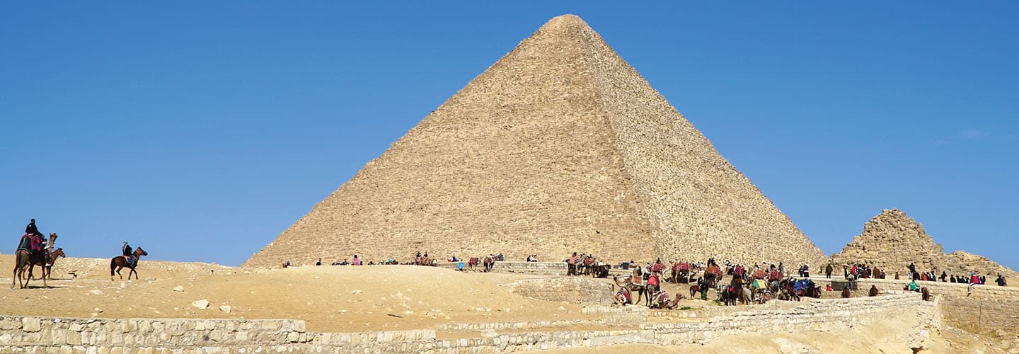 The Great Pyramid of Giza with visitors and camels gathered at its base